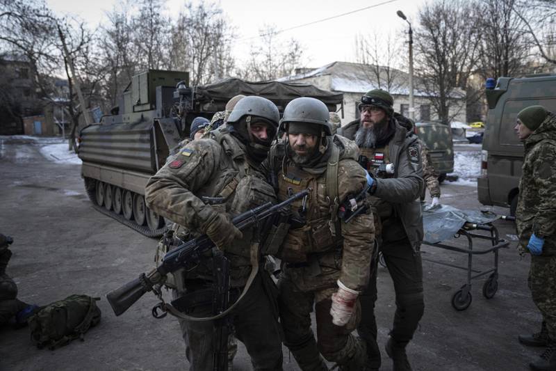 A Ukrainian serviceman carries his injured comrade from the battlefield to a hospital in the Donetsk region. AP