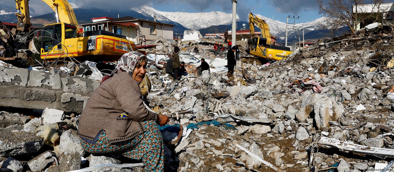 A woman sits amidst rubble and damages following an earthquake in Gaziantep, Turkey.