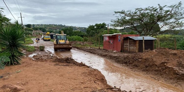 A tractor on the road following heavy rains and flooding.