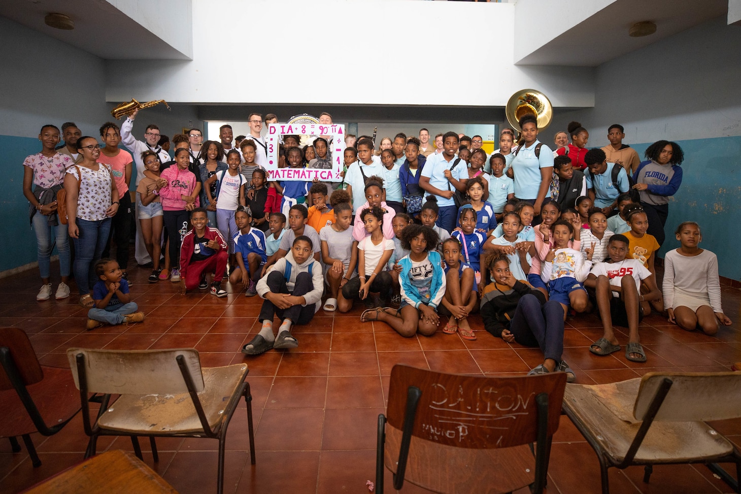 Marines and Sailors perform for students at the Escola Dona Tututa in Sal Island, Cabo Verde, Mar. 18, 2023. Marines and sailors supporting the African Maritime Forces Summit (AMFS), toured Sal Island and met with local students in a unique opportunity to learn about their culture prior to the opening day of the summit on March 20. Hosted by U.S. Naval Forces Europe and Africa (NAVEUR-NAVAF), the African Maritime Forces Summit (AMFS) is a strategic-level forum that brings African maritime and naval infantry leaders together with their international partners to address transnational maritime security challenges within African waters including the Atlantic Ocean, Indian Ocean, and Mediterranean Sea.