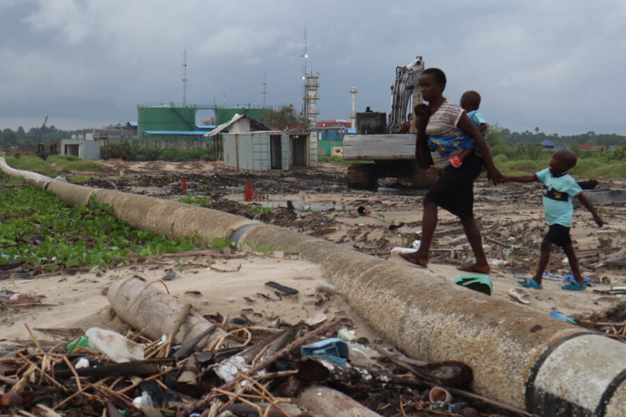 Locals cross an oil pipeline. Experts say oil exploration has made flooding worse in the Niger Delta as well as contributing to climate climate. Credit: Ekpali Saint.