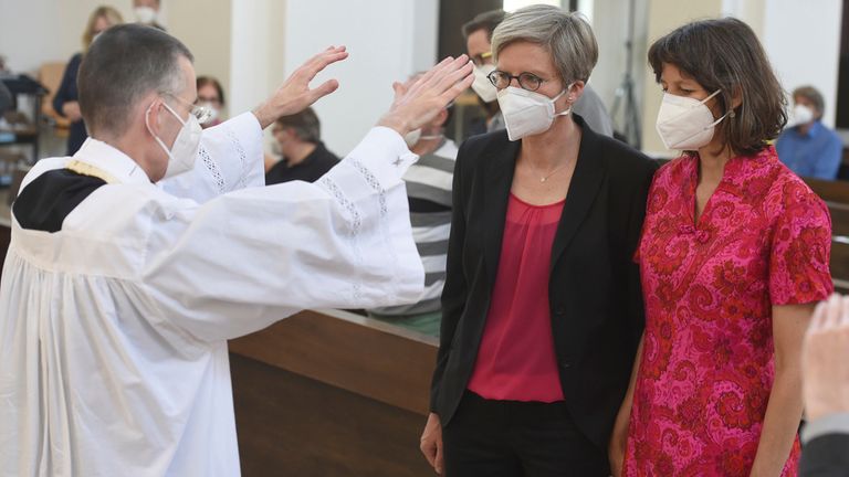 FILE - Vicar Wolfgang Rothe, left, blesses the couple Christine Walter, center, and Almut Muenster, right, during a Catholic service with the blessing of same-sex couples in St Benedict's Church in Munich, on May 9, 2021. Pope Francis has formally approved allowing priests to bless same-sex couples. File pic: AP