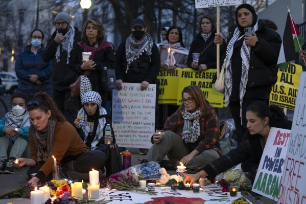Demonstrators light candles during a vigil outside the Israeli Embassy, Monday, Feb. 26, 2024, in Washington. An active-duty member of the U.S. Air Force died after he set himself ablaze outside the Israeli Embassy in Washington, while declaring that he "will no longer be complicit in genocide." (AP Photo/Mark Schiefelbein)