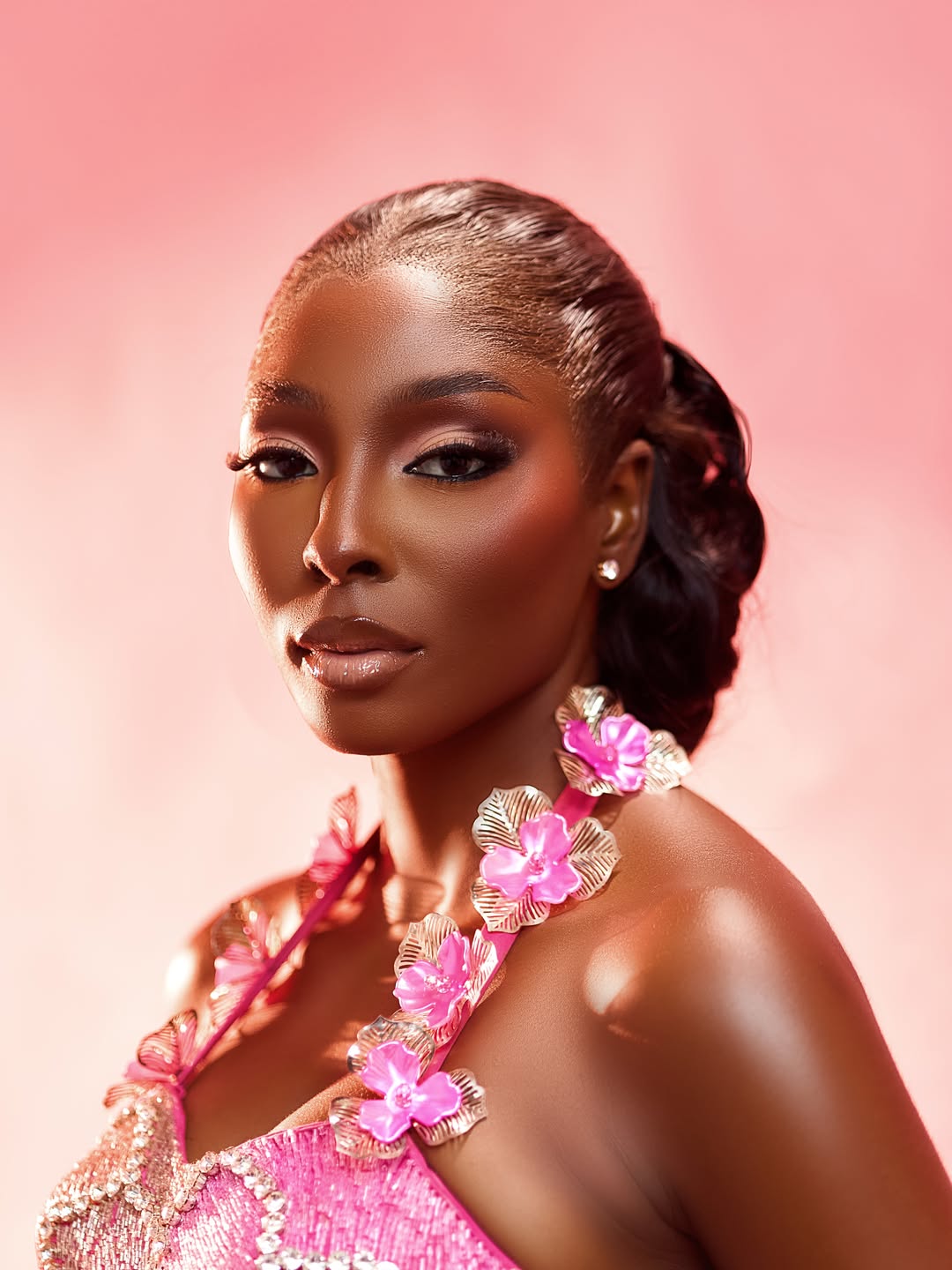 Close-up beauty portrait of Tamunosoye Karibi George showcasing a pink beaded neckline with prominent sculptural 3D pink and silver metallic flowers.